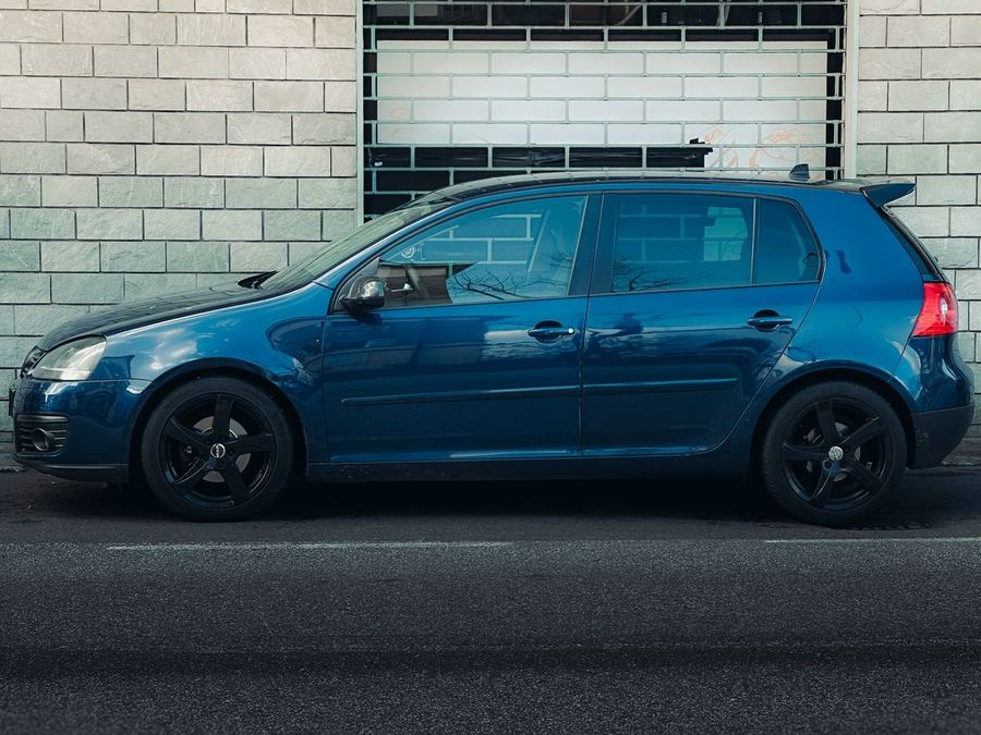 Blue hatchback parked on a city street