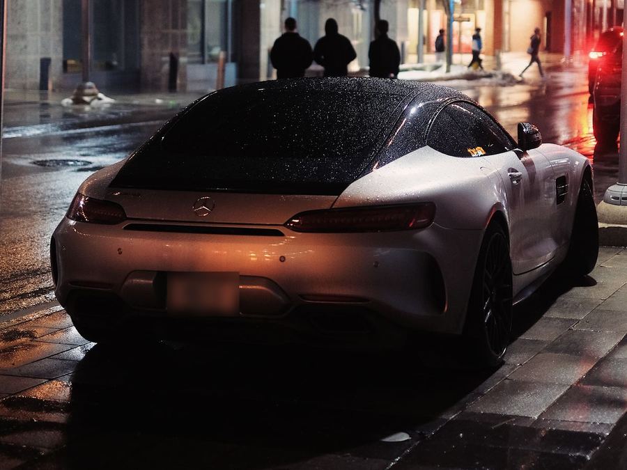Silver sports coupe on a wet street at night